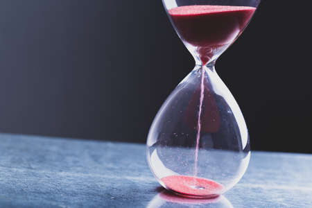 Hourglass as a concept of passing time for business deadline, urgency and outcome of time.の写真素材