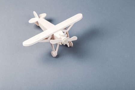 Model of a wooden toy plane, airliner, on a blue background. travel and transport conceptの写真素材