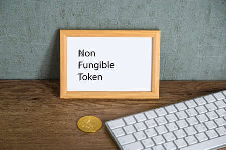 NFT non - fungible tokens inscription in the art frame. A non-fungible token (NFT) is a special type of cryptographic token which represents something unique.の写真素材