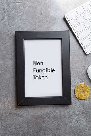 NFT non - fungible tokens inscription in the art frame. A non-fungible token (NFT) is a special type of cryptographic token which represents something unique.の写真素材