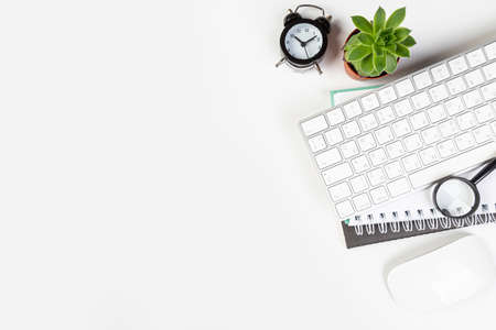 White office desk with blank laptop, computer keyboard and other stationery, potted plant. Top view with copy space, top viewの写真素材