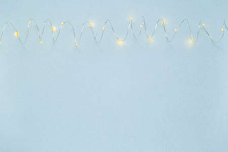 The garland is on. Glowing electric garland on a light blue background. top view