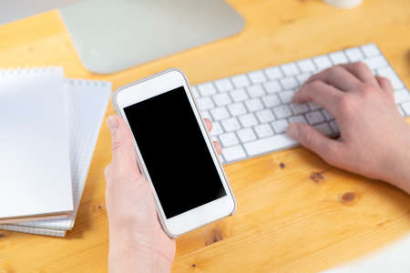 woman hands close up working on white computer keyboard and smartphone, work from home concept. work online, shoppingの写真素材