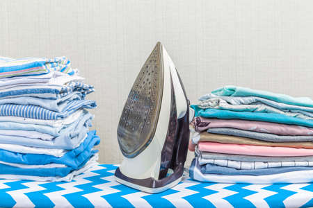New modern iron and clean clothes on board indoors. Laundry dayの写真素材