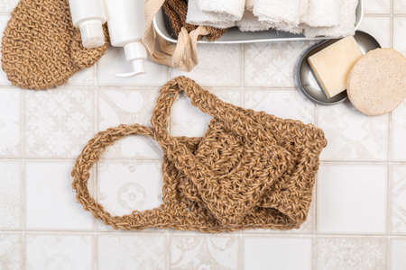 natural materials for bathroom accessories. bath sponges, washcloths, soap and towels on a light...