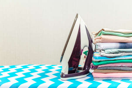 New modern iron and clean clothes on board indoors. Laundry dayの写真素材