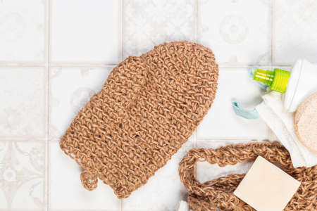 natural bathroom accessories, loofah glove mitten for the body, soap, cream, bath salt and towels on a light background. waste-free, environmentally friendly houseの写真素材