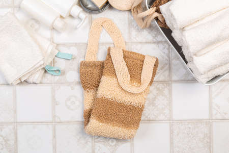natural materials for bathroom accessories. bath sponges, washcloths, soap and towels on a light...