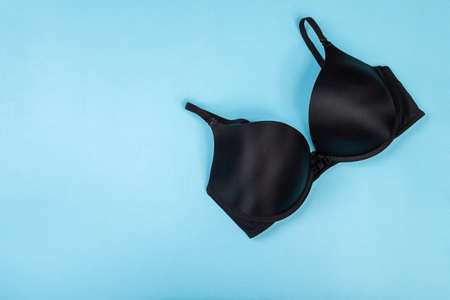 Top view of womens comfortable bra on turquoise background with copy space. Women's wardrobe, shopping concept. Underwear.の写真素材