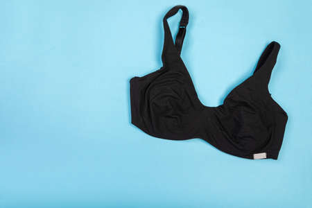 Top view of womens comfortable bra on turquoise background with copy space. Women's wardrobe, shopping concept. Underwear.の写真素材