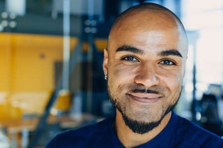 Happy african american businessman or or creative man with tablet in hands in modern free office, coworkingの写真素材