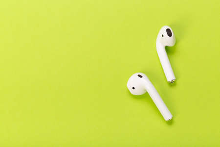 modern white wireless headphones on green backgroundの写真素材