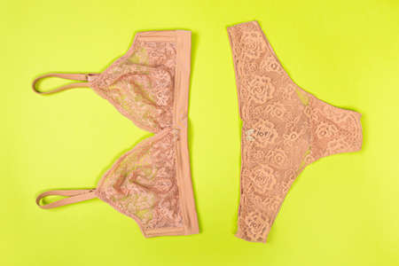 top view of fashionable bra and panties set on green background Female wardrobe, shopping concept....