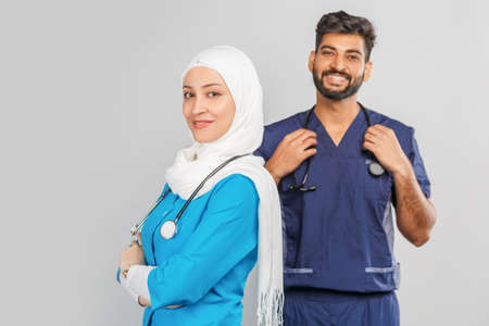 professional muslim doctor woman and indian assistant discuss tasks. portrait of beautiful medical workers with stethoscopes. Medical help, insurance in health care and medicine conceptの写真素材