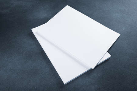 White business card sheet of paper a4 stack on a dark table. cold toned photo