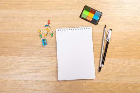 Working table with keyboard and notepad, pen, pencil and plant in home office. top view