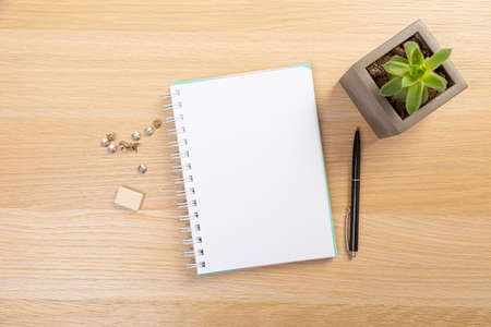 Working table with keyboard and notepad, pen, pencil and plant in home office. top view