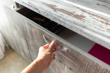 male hand are open the cupboard doors, light wood.