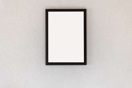empty picture frame hanging on a white wall in the roomの写真素材
