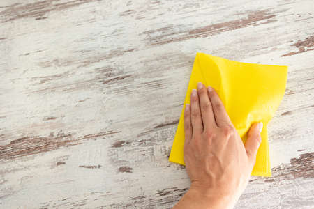 Cleaning yellow napkin in the hands of a woman. cleaning service. The concept of disinfection....