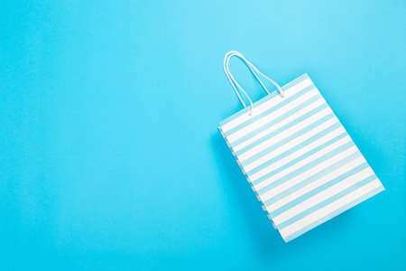Eco-friendly recyclable paper gift bag with handles on blue backgroundの写真素材