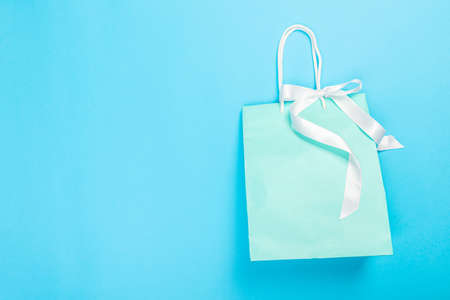 Eco-friendly recyclable paper gift bag with handles on blue backgroundの写真素材