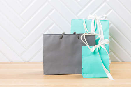 Paper bags on wooden table against white background, copy space. Commercial, sale and advertisement concept. Mock upの写真素材
