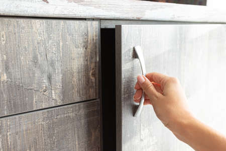 male hand are open the cupboard doors, light wood.の写真素材