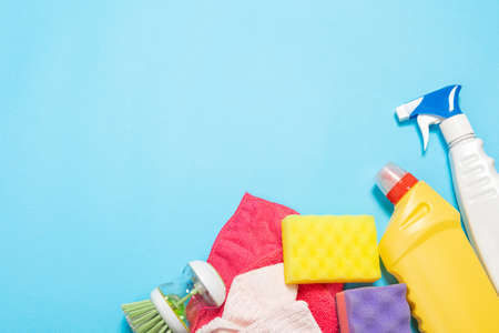 bottles and sprays cleaning agent brushes sponges rags on a colored background on the side. Professional cleaning products, general cleaning. Household chemicalsの写真素材