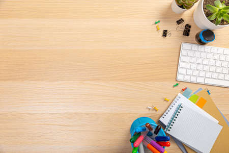 Wooden office table with laptop, coffee cup and supplies. Top view with copy space, flat lay.
