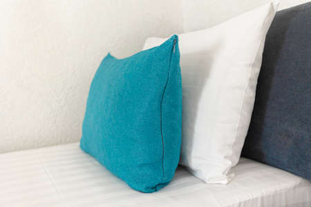 beautiful white and blue pillows lie on the bed