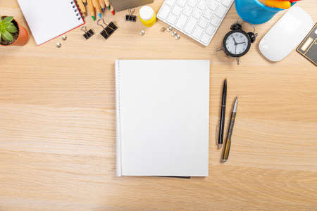 office stuff on a wooden table with office supplies and a cup of coffee, top view succulent. open notebookの写真素材