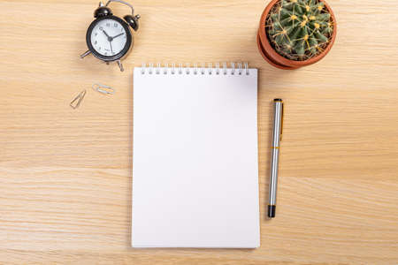 Working table with keyboard and notepad, pen, pencil and plant in home office. top viewの写真素材