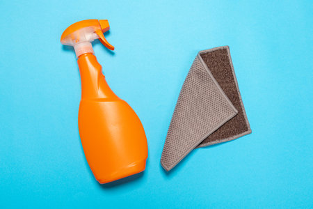 Detergent for various surfaces and a rag on a blue background. Professional cleaning products, general cleaning. Household chemicalsの写真素材