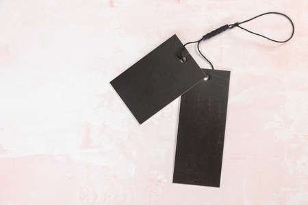 Clothing tag, label blank mockup template on pink tableの写真素材