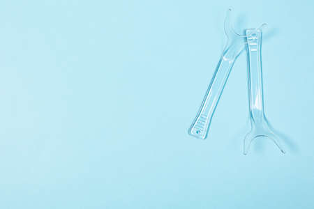 set of several Retractor Dental lip retractor Access to the oral cavity. Wide mouth opening for a dental procedure on a blue backgroundの写真素材