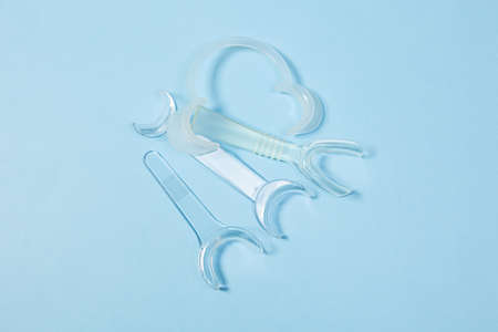 set of several Retractor Dental lip retractor Access to the oral cavity. Wide mouth opening for a dental procedure on a blue backgroundの写真素材