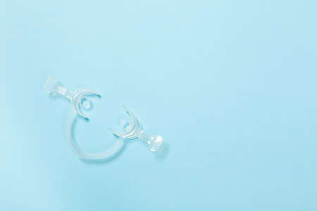 Retractor Dental lip retractor Access to the oral cavity. Wide mouth opening for a dental procedure on blueの写真素材