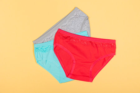 Clothing for children in the form of panties. Clothes for children from soft fabric. panties for girls. A set of panties for children. view from above. Underwear set. Set of underwear on a yellow backgroundの写真素材