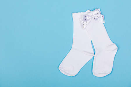 high white children's socks with big bows for festive clothes on a blue backgroundの写真素材