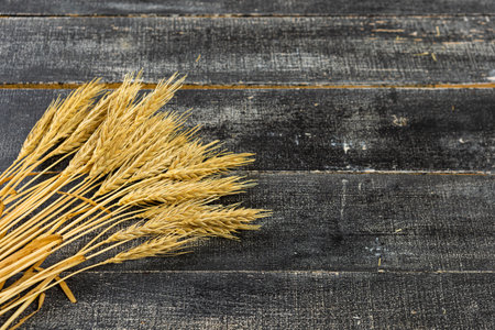 Wheat Ears on the Wooden Table. Sheaf of Wheat over Wood Background. harvest conceptの写真素材