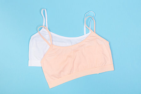 Clothes for children in the form of a bra top on a blue background. Clothes for children from soft fabric. top view flat lay with copy space for text.の写真素材