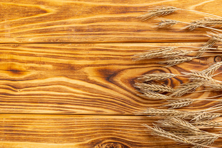 Wheat Ears on the Wooden Table. Sheaf of Wheat over Wood Background. harvest conceptの写真素材