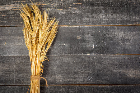 Wheat Ears on the Wooden Table. Sheaf of Wheat over Wood Background. harvest conceptの写真素材
