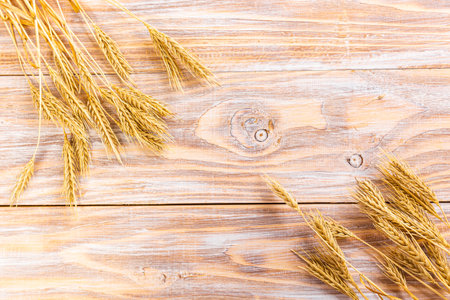Ripe ears of wheat on the background of an old wooden table. Top view, flat layの写真素材