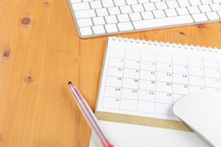 Calendar and agenda reminders, work from home online. desktop calendar with stationery and pen pencil, keyboard. mark a holiday trip or plans in a diary at the office desk. 2023 calendar reminder concept.の写真素材
