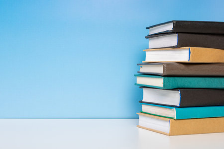 Composition with vintage old hardback books, diary on wooden table and blue background. Book stacking. back to school. copyspace. education background.の写真素材