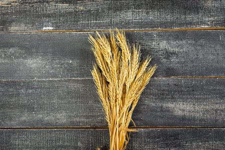Wheat Ears on the Wooden Table. Sheaf of Wheat over Wood Background. harvest conceptの写真素材