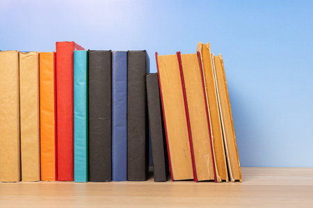 Composition with vintage old hardback books, diary on wooden table and blue background. Book stacking. back to school. copyspace. education background.の写真素材