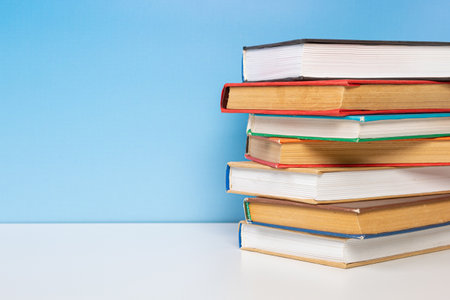 Composition with vintage old hardback books, diary on wooden table and blue background. Book stacking. back to school. copyspace. education background.の写真素材